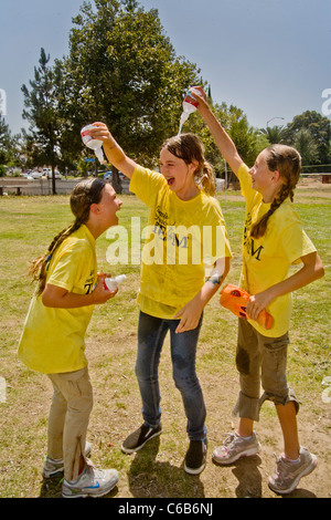 Teenie Mädchen Gießen Sie kaltes Wasser über einander an einem heißen Nachmittag in Orange, Kalifornien. Stockfoto