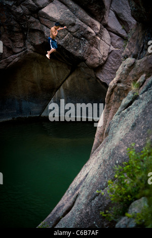 Ein Junge von einem Cliff Felsen Tauchen Stockfoto