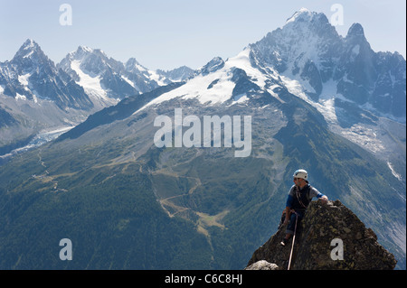 Eine männliche Kletterer auf einem Gipfeltreffen in Chamonix mit Grandes Montets im Hintergrund Stockfoto