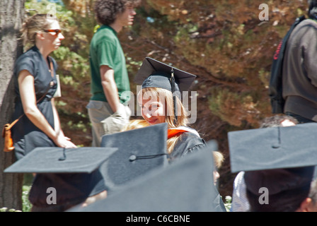 Glücklich Absolvent kehrt zurück zu ihrem Platz nach ihrem Diplom bei der Abschlussfeier am St. Johns College in Santa Fe. Stockfoto