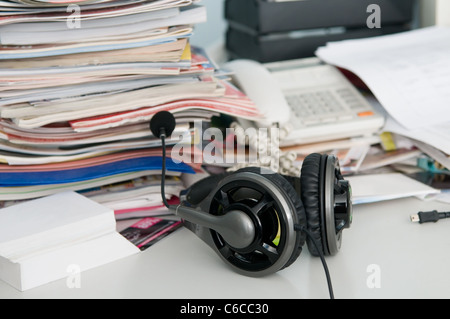 Kopfhörer mit Mikrofon und ein Durcheinander auf dem Tisch Stockfoto