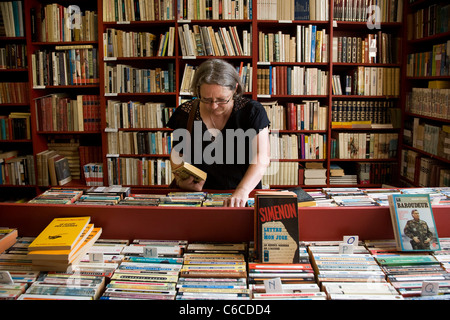 Frau auf der Suche nach Bücher im Buchladen in der Bücherstadt Redu, Ardennen, Luxemburg, Belgien Stockfoto