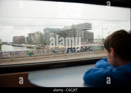 Young Boy Blick aus dem Zug Fenster Amsterdam Niederlande Holland Europa Stockfoto