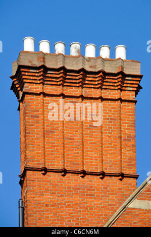 Nahaufnahme von Cluster aus rotem Backstein gebaut corbeled Schornsteine Stacks & Schornstein Töpfe hoch über Dachhöhe blauer Himmel Tag London England Großbritannien Stockfoto