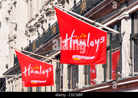 Das Hamleys-Logo auf roten Bannern über dem berühmten Spitzengeschäft des Spielwarenladens im Londoner West End in der Regents Street England UK Stockfoto