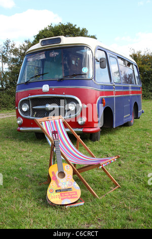 1971 Bedford Wohnmobil geparkt in einem Feld mit einer akustischen Gitarre und einem Liegestuhl im Vordergrund. Stockfoto