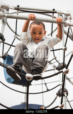 Gemischte Rassen junge Klettern auf Spielplatz Stockfoto