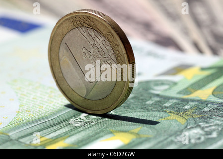 ein-Euro-Münze auf einer 100-Euro-banknote Stockfoto