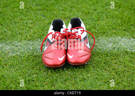 Paar rote Nike Fußballschuhe auf die weiße Linie eines Fußballfeldes. Stockfoto