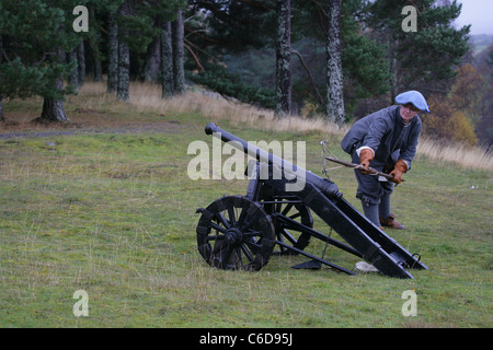 Mitglied der [Frasers Dragoner], ein 17. Jahrhundert Reenactment Gesellschaft, Abfeuern einer Kanone durch die Anwendung einer beleuchteten Sicherung [Touch Hole] Stockfoto