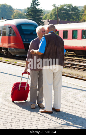 Reifen entscheidend älteres Ehepaar am Bahnhof. Unterwegs im Urlaub Stockfoto