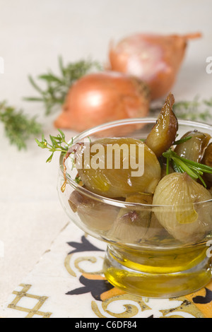 gebackene Zwiebeln in Öl, mit rohen Zwiebeln Hintergrund Stockfoto