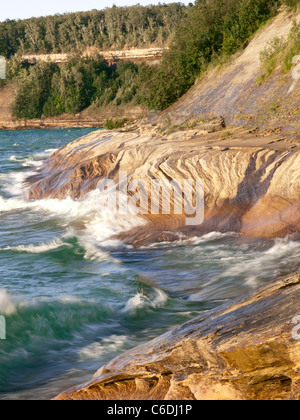 Wellen fegen über die Sandstein-Küste von dargestellter Felsen-Staatsangehöriger Lakeshore und schöne Designs in den Felsen schnitzen. Stockfoto