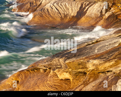 Wellen fegen über die Sandstein-Küste von dargestellter Felsen-Staatsangehöriger Lakeshore und schöne Designs in den Felsen schnitzen. Stockfoto