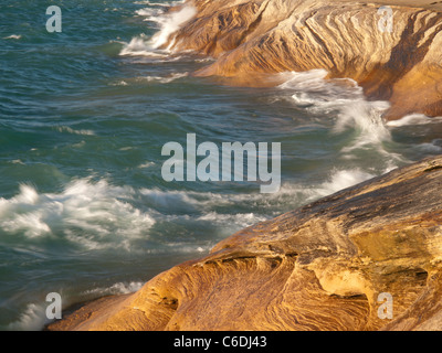 Wellen fegen über die Sandstein-Küste von dargestellter Felsen-Staatsangehöriger Lakeshore und schöne Designs in den Felsen schnitzen. Stockfoto