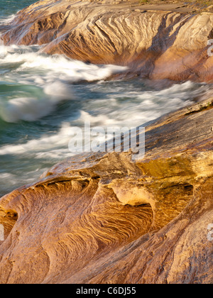 Wellen fegen über die Sandstein-Küste von dargestellter Felsen-Staatsangehöriger Lakeshore und schöne Designs in den Felsen schnitzen. Stockfoto