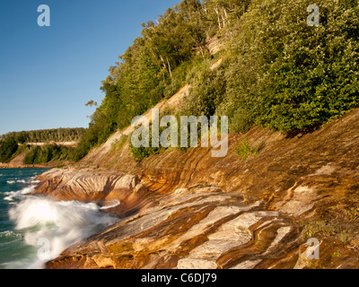 Wellen fegen über die Sandstein-Küste von dargestellter Felsen-Staatsangehöriger Lakeshore und schöne Designs in den Felsen schnitzen. Stockfoto