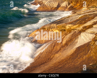 Wellen fegen über die Sandstein-Küste von dargestellter Felsen-Staatsangehöriger Lakeshore und schöne Designs in den Felsen schnitzen. Stockfoto