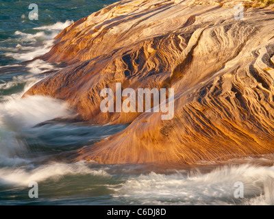 Wellen fegen über die Sandstein-Küste von dargestellter Felsen-Staatsangehöriger Lakeshore und schöne Designs in den Felsen schnitzen. Stockfoto