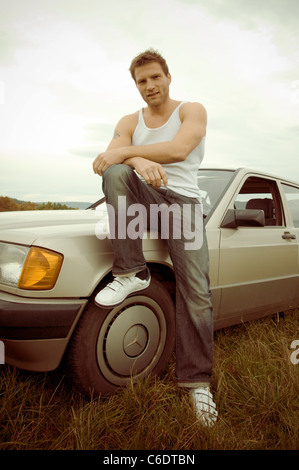 Mann mit Mercedes-Wagen in einem 80er Jahre look Stockfoto