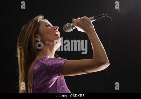 Frau, Jersey City, New Jersey, USA singen im Rampenlicht Stockfoto