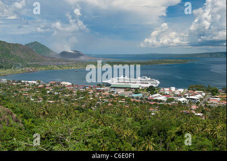 Blick auf Rabaul Stadt mit Kreuzfahrtschiff und aktiven Vulkan Tavurvur in der Ferne, East New Britain, Papua New Guinea Stockfoto