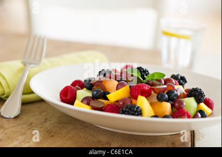 Salat von frischen Früchten in Schüssel auf Tisch Stockfoto