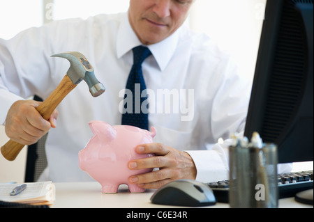USA, New Jersey, Jersey City, Geschäftsmann Hämmern Sparschwein Stockfoto