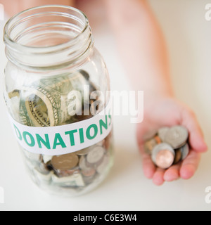 USA, New Jersey, Jersey City, Nahaufnahme von Glas und Mädchens Hand mit Münzen Stockfoto