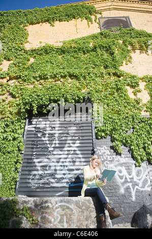 USA, Brooklyn, Williamsburg, Frau liest außerhalb Stockfoto