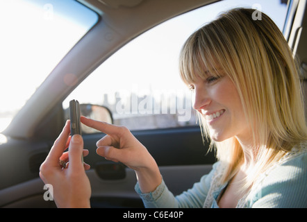 USA, Brooklyn, Williamsburg, Frau mit Smartphone im Auto Stockfoto