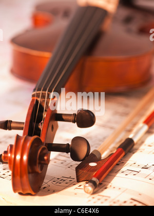 Nahaufnahme von Violine Scroll und Bogen zu den Noten Stockfoto