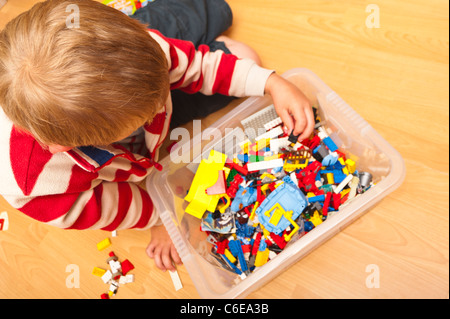 Ein sieben Jahre alter Junge spielen Lego drinnen im Vereinigten Königreich Stockfoto