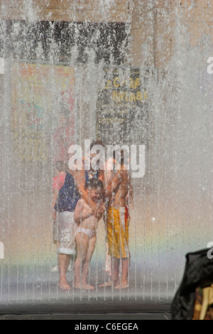 Kinder und Familien Kühlung und beim Spielen im Brunnen in der Mittagssonne in London Stockfoto