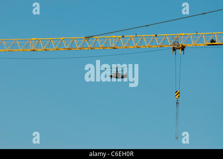 Russische militärische Hubschrauber fliegen am Bau Kran Hintergrund Stockfoto