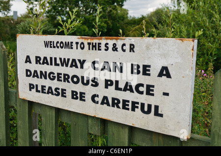 Schild Warnung Passagieren und Besuchern, vorsichtig zu sein in der Nähe von Gleisanlagen Stockfoto