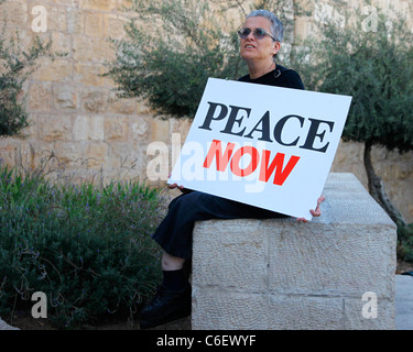 Eine israelische linksgerichtete Aktivistin hält ein Zeichen, das "Peace Now" heißt, während sie an einer Kundgebung zur Förderung einer zwei-Staaten-Lösung des israelisch-palästinensischen Konflikts teilnimmt. Ost-Jerusalem Israel Stockfoto