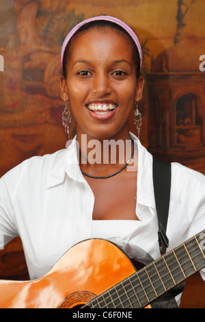 Jungen kubanischen Mädchen spielt Gitarre in der Band. Begrüßung für die Besucher einer Rom-Fabrik. Havanna, Kuba, Oktober 2010 Stockfoto