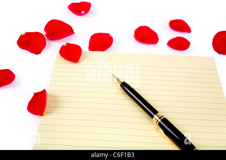 rote Rosenblätter und Briefpapier im weißen Hintergrund, Liebe Konzept Stockfoto