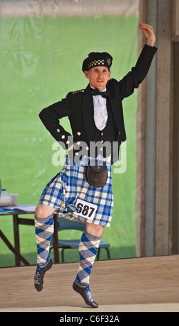 Junger Mann in Tracht, die im Wettbewerb mit einem Highland Dance Wettbewerb, Cowal Highland Gathering 2011 Stockfoto