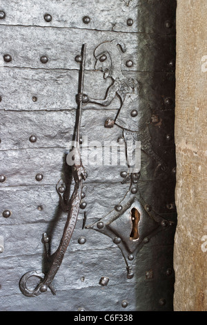 Alte Kirche Tür bedeckt mit Eisen-Schutz, verziert mit einem Drachen und Ritter zu behandeln. In Kirche von Kungslena, Schweden Stockfoto
