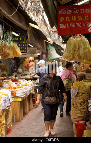 Passanten in der schmalen Straße ein Chinatown-Lebensmittelmarkt mit Taschen von die lokale Spezialität von frittiertem Fisch Mut aufhängen Stockfoto