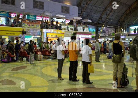 Menschen stehen bei der täglichen 18.00 Nationalhymne bei der Hua Lamphong Grand Central Railway Station in Bangkok Stockfoto