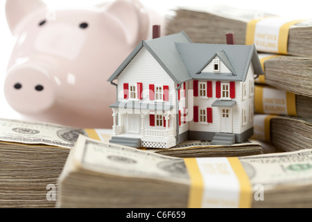 Kleines Haus und Sparschwein mit Stapeln von hundert-Dollar-Scheine, Isolated on White Background. Stockfoto