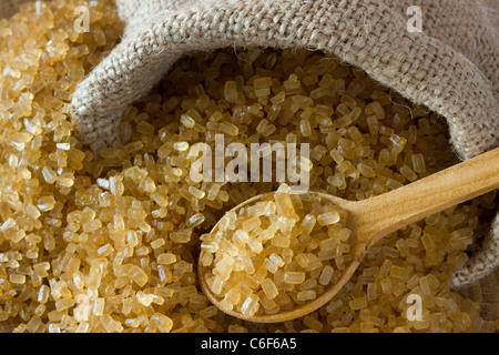 Kochlöffel und gesunde Rohrzucker in kleinen Sackleinen Stockfoto