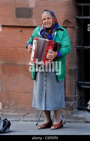Alte Dame eingewanderte Gaukler spielen Akkordeon auf der Buchanan Street in Glasgow, Schottland, Großbritannien Stockfoto