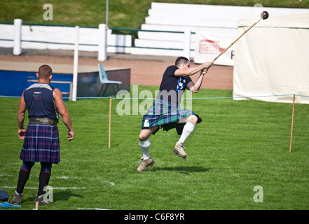 Konkurrent in der schottischen Hammerwurf in den schweren Ereignissen auf der Cowal Highland Gathering 2011, beobachtet von einem anderen Teilnehmer Stockfoto