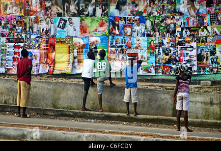 Menschen bewundern Poster zum Verkauf in Bo Stadt, Sierra Leone, Westafrika Stockfoto