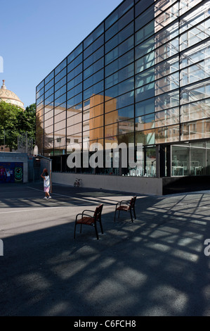 Ein Junge spielt Basketball neben einem modernen Gebäude in Barcelona Stockfoto