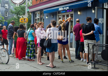 Kunden warten auf Linie außerhalb ein Restaurant im Stadtteil Greenwich Village in New York City nach dem Hurrikan Irene Stockfoto